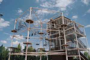 Explore the adventure high rope course set against a clear blue sky.